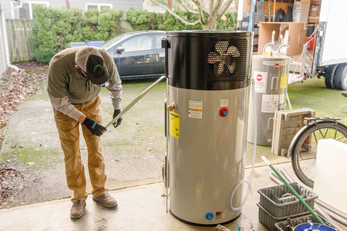 Installer measuring a heat pump water heater